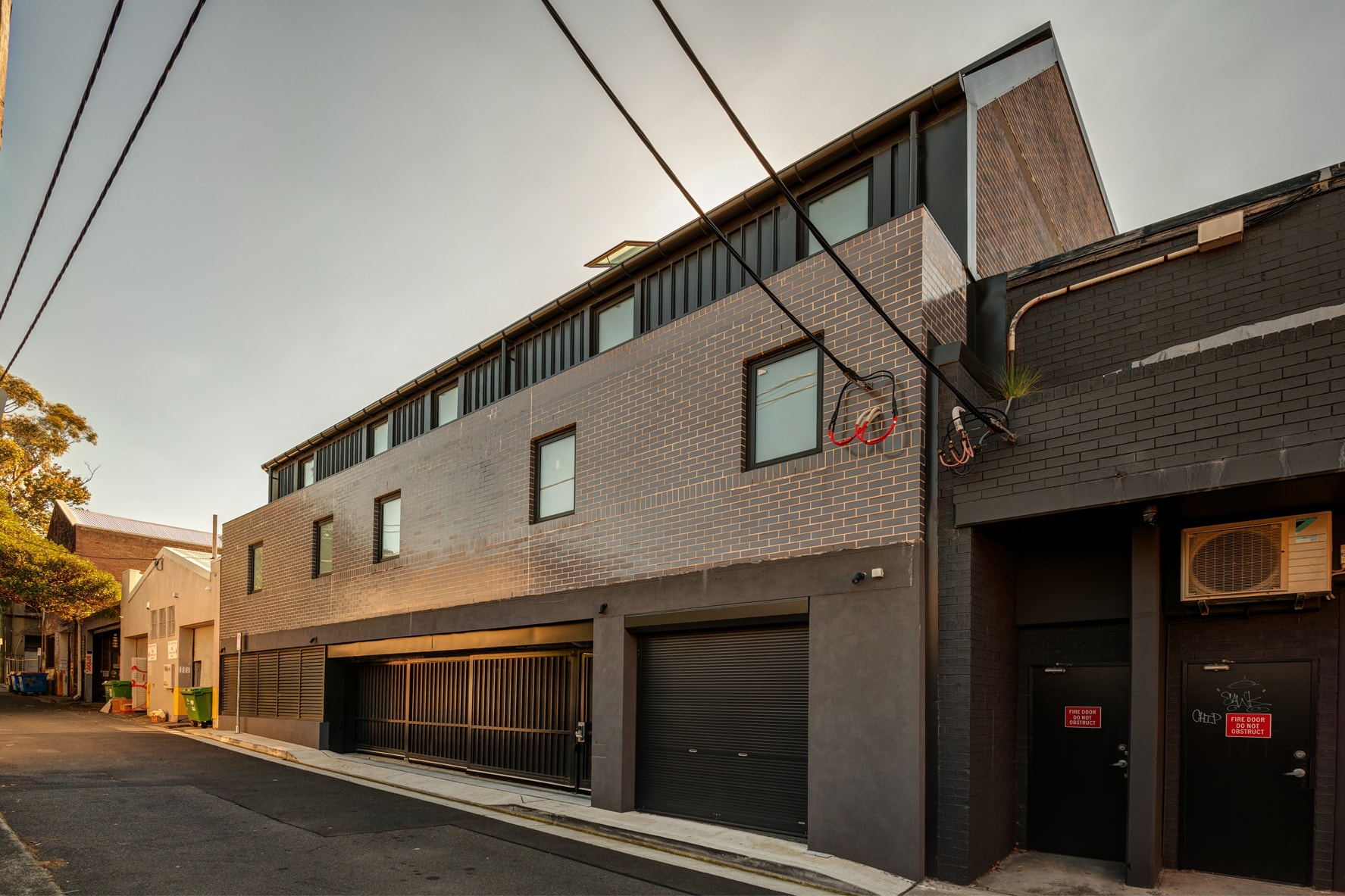Annandale boarding house rear lane elevation — dark brick facade and garage entry
